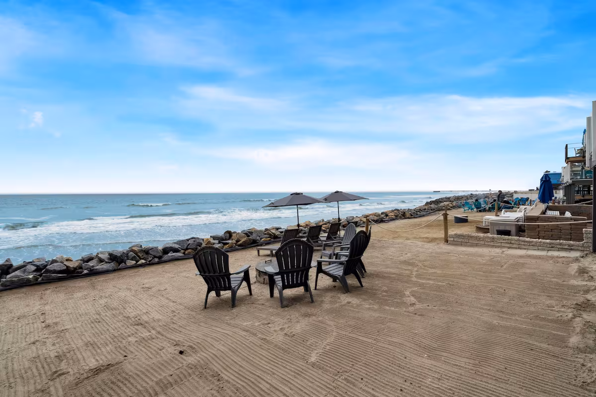 Ocean view behind the firepit and lounge chairs